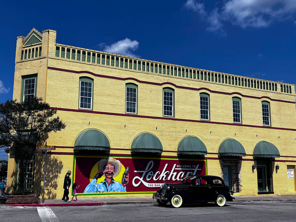 A yellow building with the Welcome to Lockhart sign