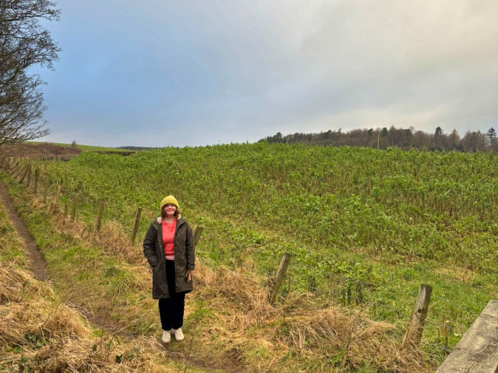 The author Louise Wylie layered up in a vast greenery