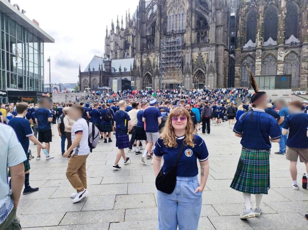The author Louise Wylie posing for a photo with crowd in front of the Cologne Cathedral
