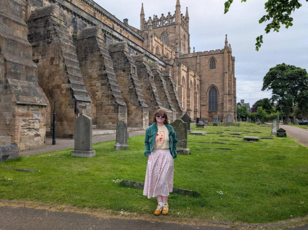 The author Louise Wylie, standing outside the Dunfermline Palace and Abbey