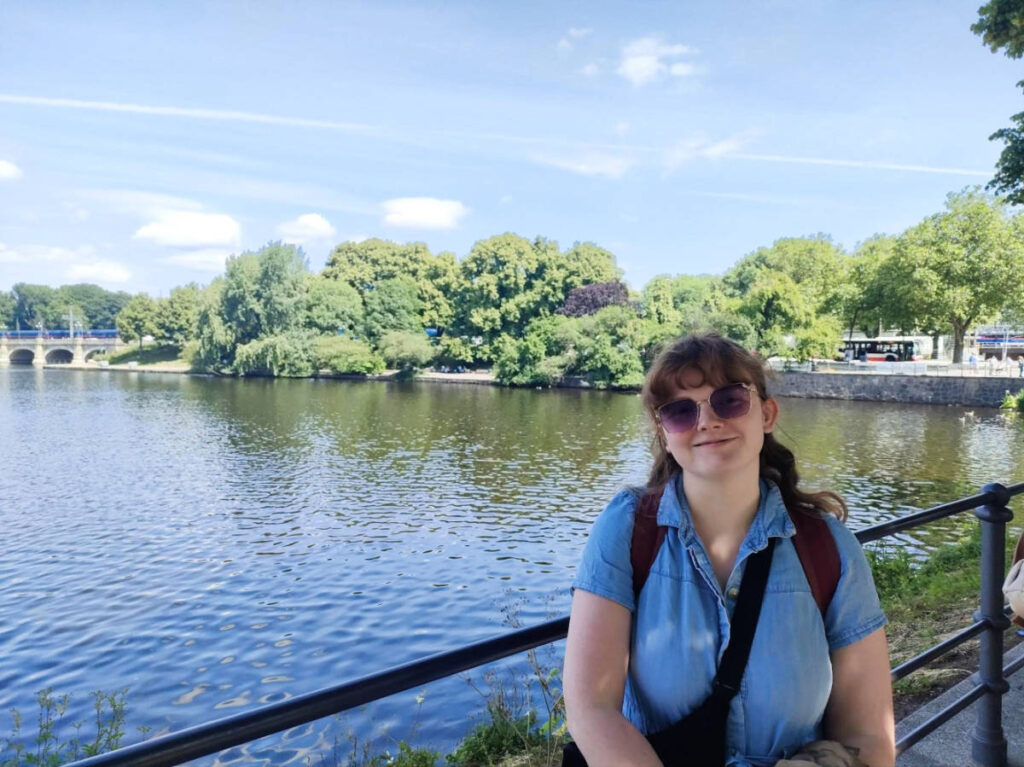 The author Louise Wylie smiling for a photo under the shade at Inner Alster Lake
