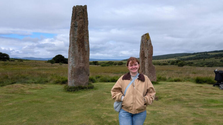 The author Louise Wylie, posing in front of the standing stones at the Machrie Moor