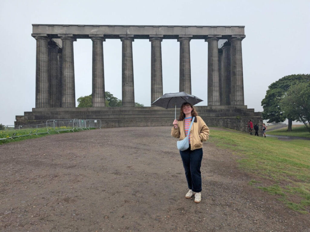 The author Louise Wylie standing in front of the incomplete National Monument on a rainy day