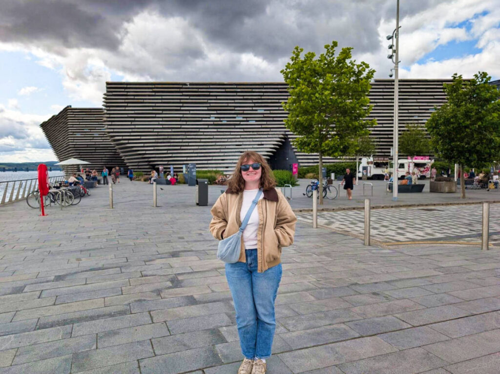 The author Louise Wylie standing in front of a unique architecture in Dundee on a gloomy day