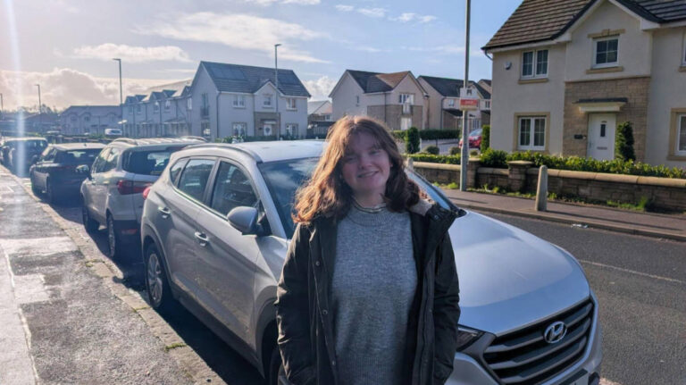 The author, Louise Wylie with cars parked on her background