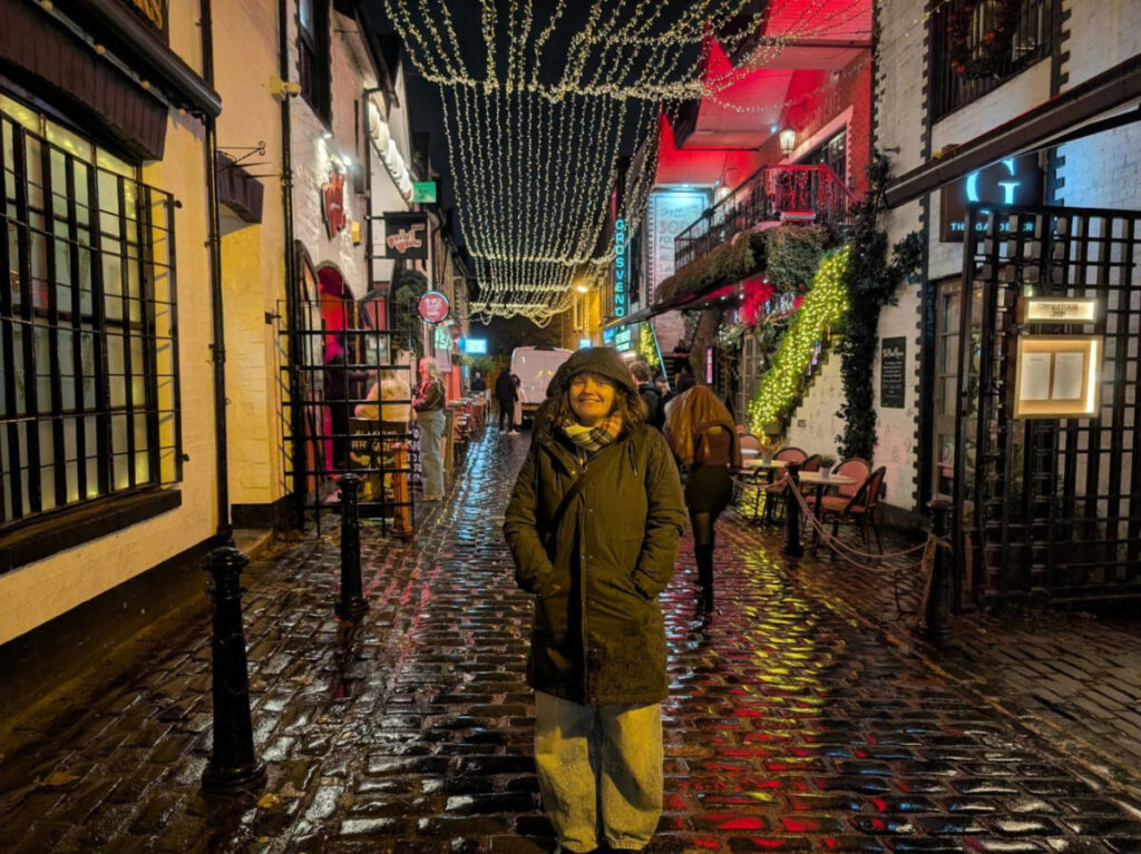 The author Louise Wylie covered with a winter coat on a rainy evening in Ashton Lane