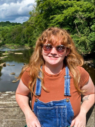 The author Louise Wylie posing for a photo at Chatelherault Country Park on a sunny day