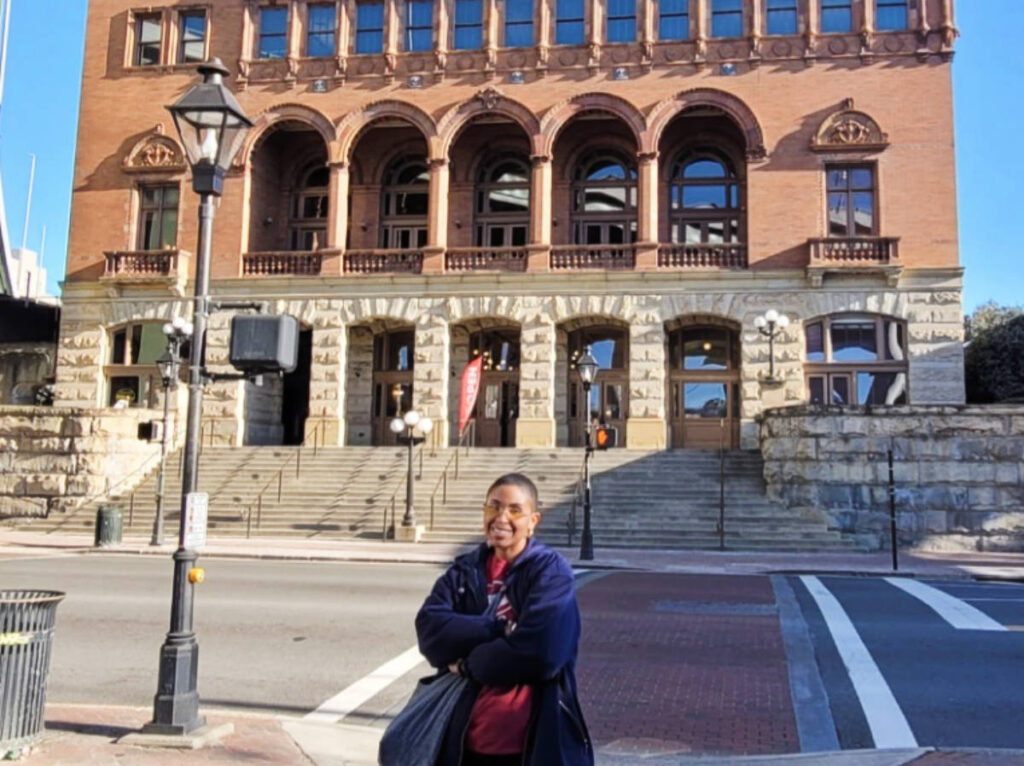 The author, Jonaye Barnum smiling for a photo in front of the Main Street Station in Shockoe Bottom