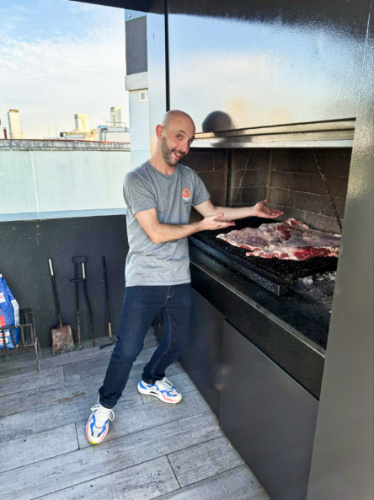 A man showing the grill with meat