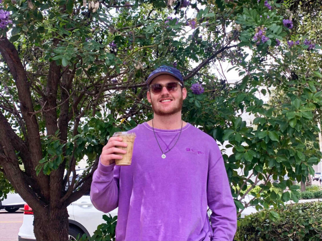A man holding a cup of coffee from Fourtillfour Cafe