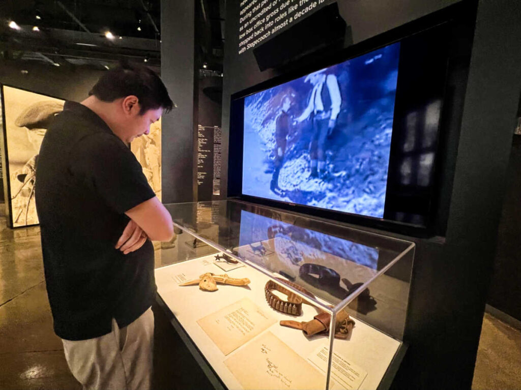 A man looking down the display inside John Wayne Museum