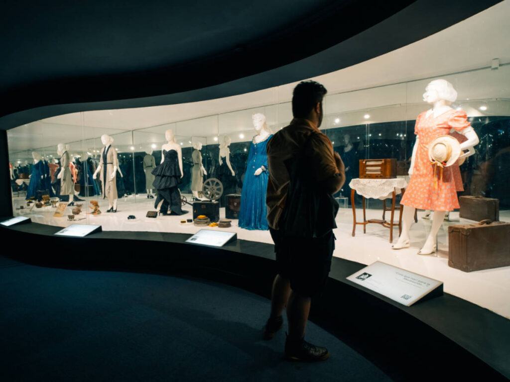 A man looking at the exhibit of dresses inside Museo Evita