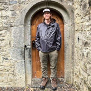 A man standing at the doorway with his hands on the pockets