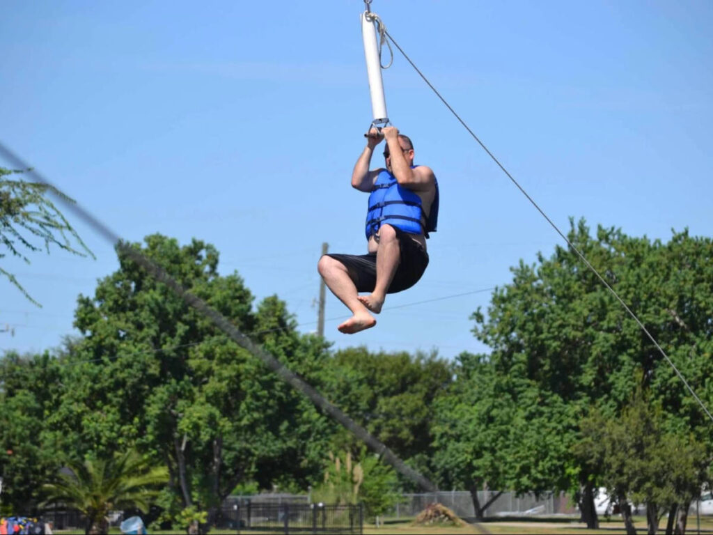 A man ziplining over the Hidden Lake