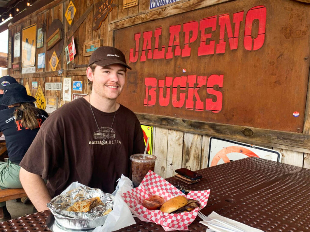 The author's boyfriend, smiling for a photo with his food at the Jalapeno Bucks