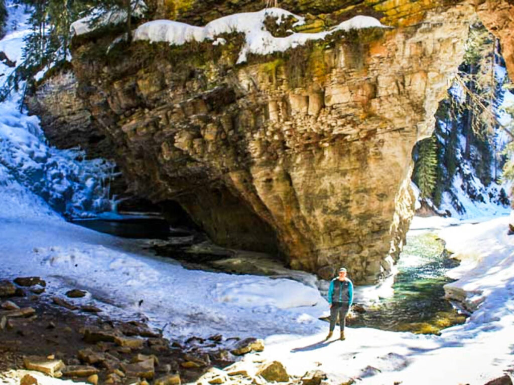 A man at the snowy Johnston Canyon