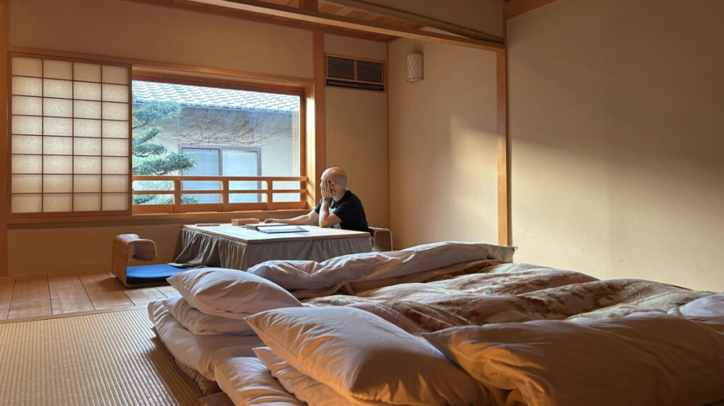 Author's husband looking out the window from the Ryokan Motonago room