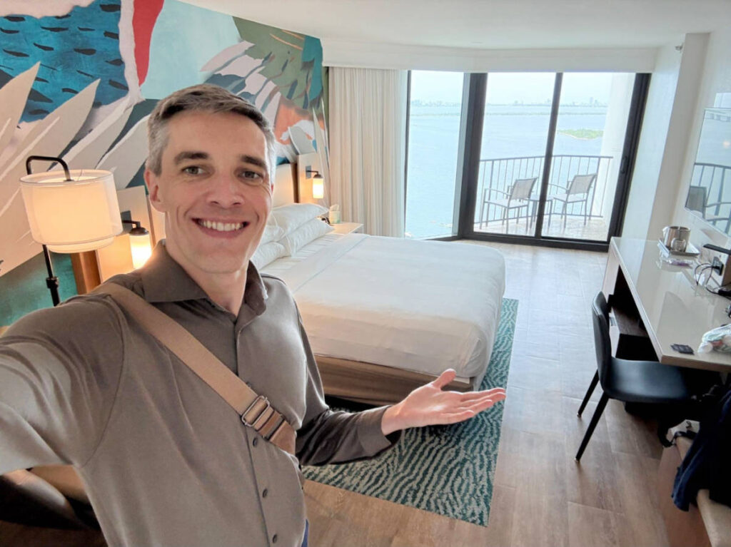 Travel Lemming founder, Nate Hake smiling for a selfie on his room at Marriott Miami Biscayne Bay