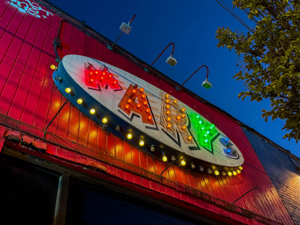 Exterior view of the brightly lit sign outside Mary’s