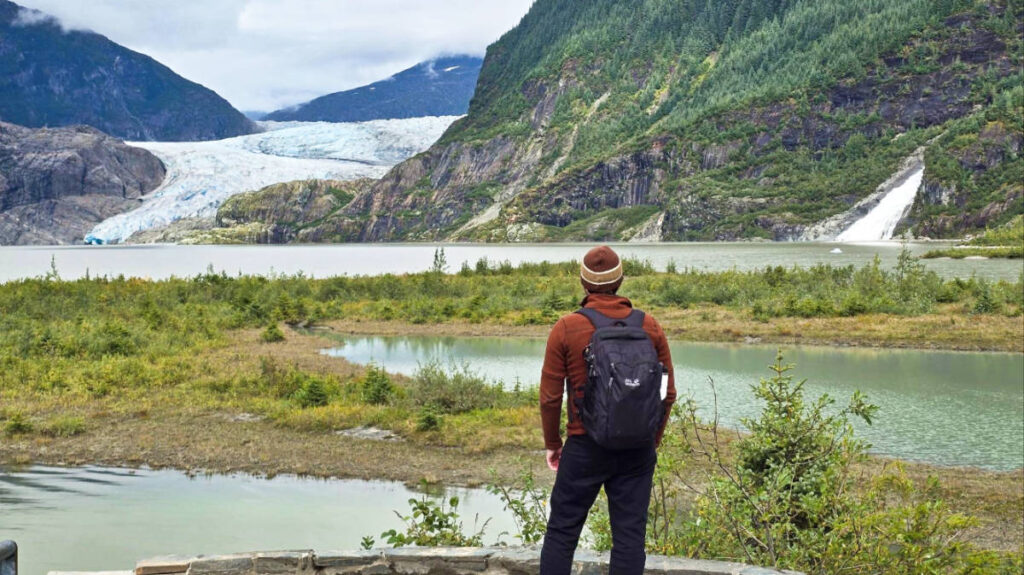 The author Matthew Reppond looks out at the Mendenhall Glacier and Nugget Falls