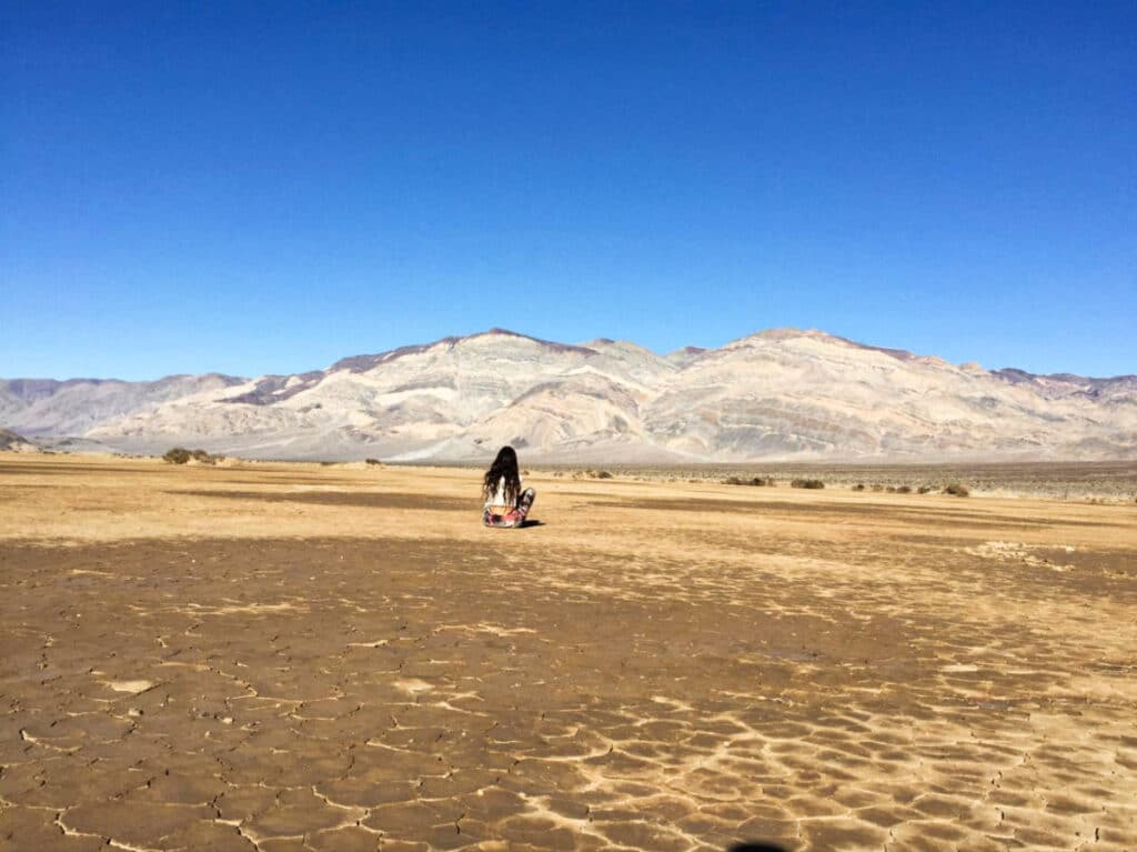 The author McKenna Mobley, sitting on the ground at the Badwater Basin