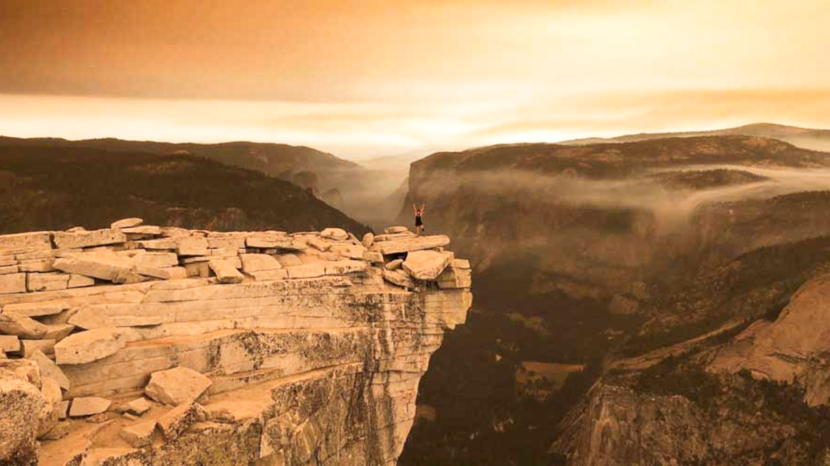 Travel Lemming Writer, McKenna posing at the top of the Half Dome Cables in Yosemite National Park at sunset