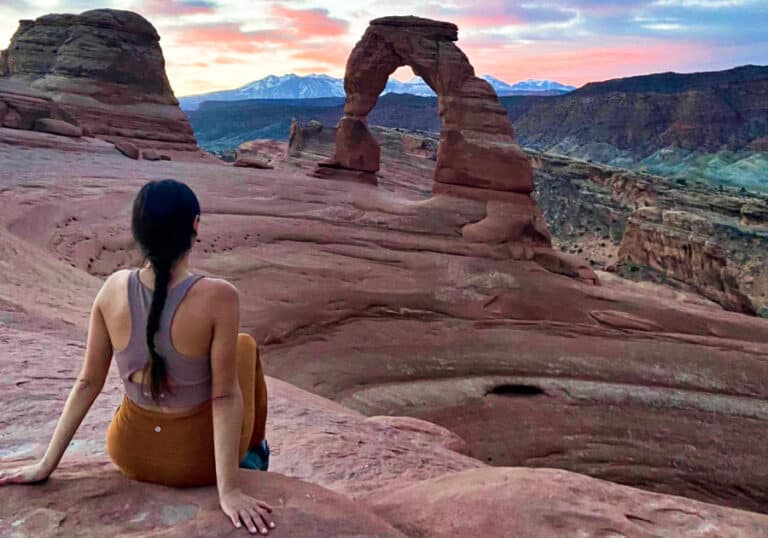 The author McKenna Mobley posing in Arches National Park at sunrise