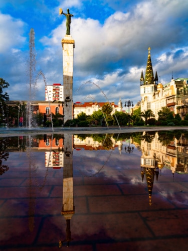 View of the Medea Statue and other buildings reflecting on the water at Europe Square