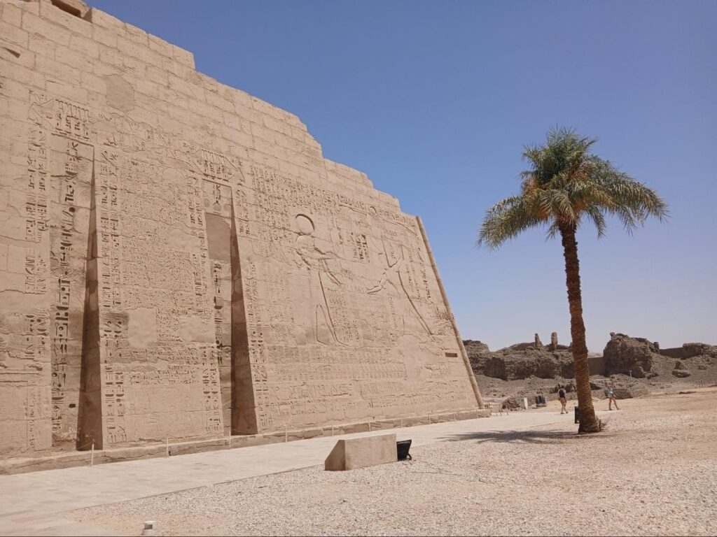Exterior wall of Medinet Habu temple in Luxor covered in carved hieroglyphs