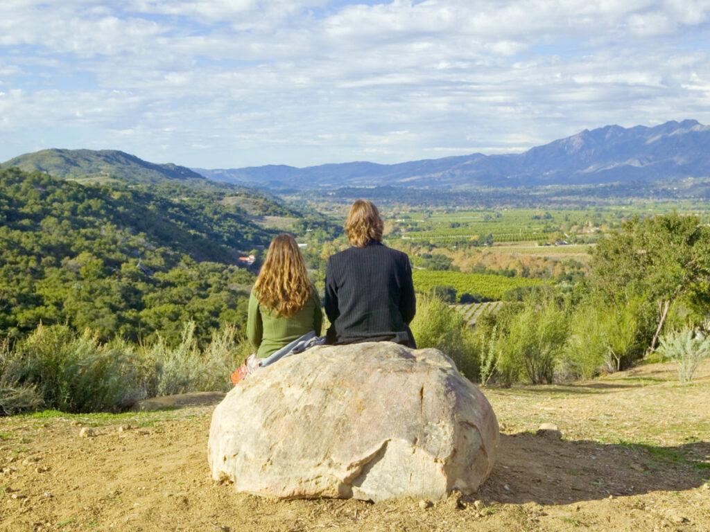 Two people seated on a rock, enjoying the serene view at Meditation Mount