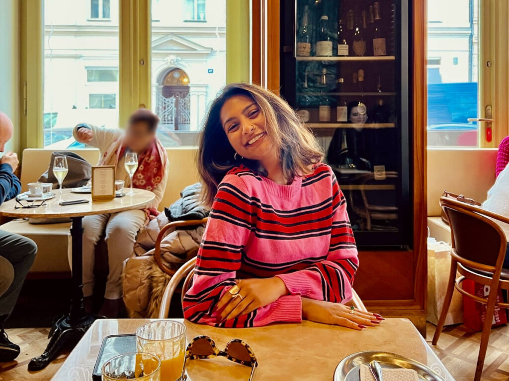 The author Meera Devotta sitting inside Cafe Savoy
