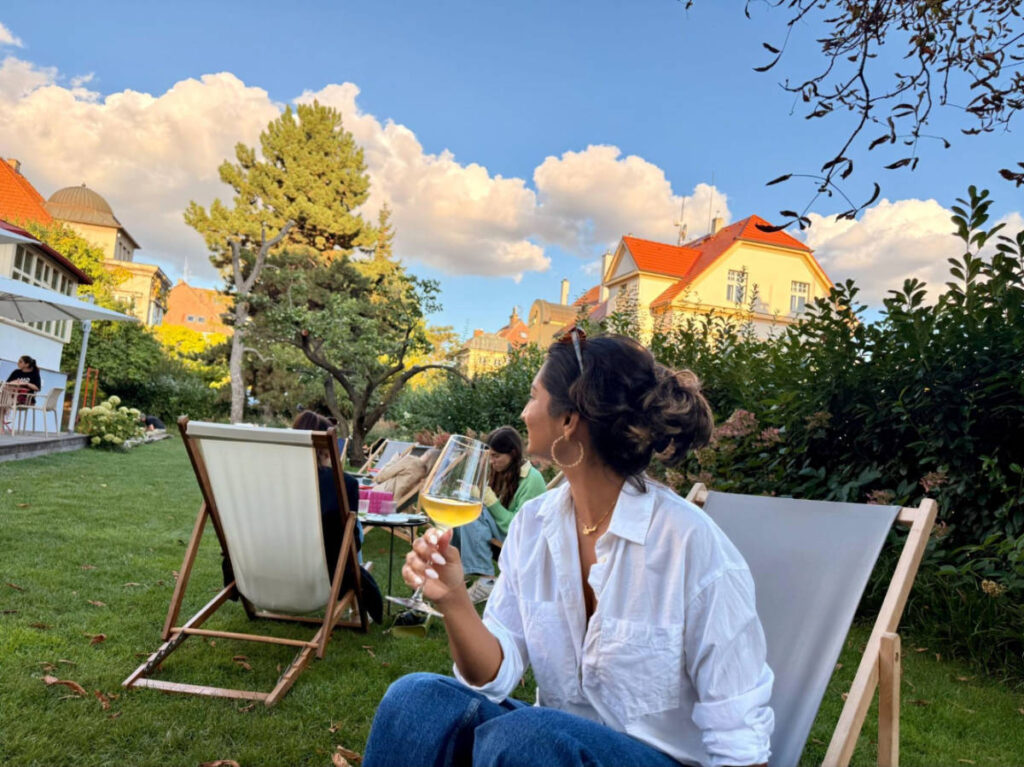 The author Meera Devotta drinking wine outside Vila 63