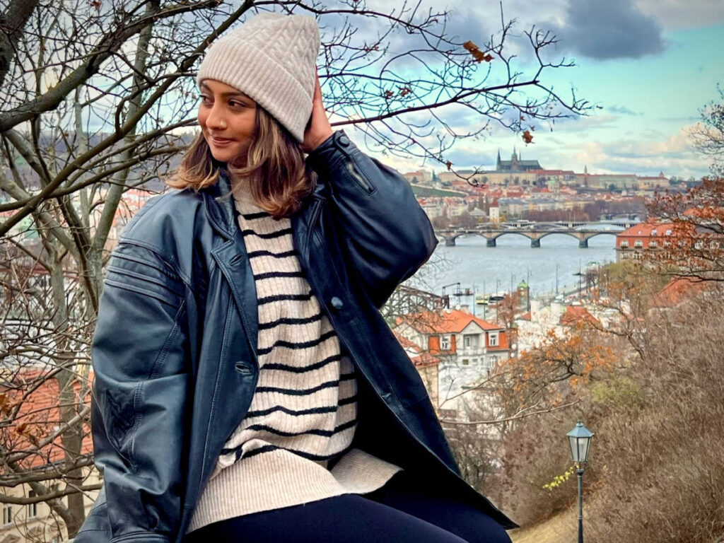 The author Meera Devotta posing for a photo at the Vyšehrad’s Castle Walls with an overlooking view in the background