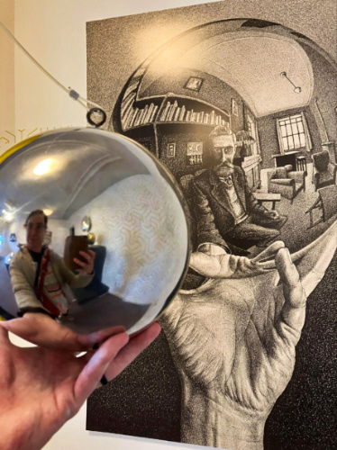 The author Meg O’Connor taking a photo of herself on the mirror ball at Escher Museum