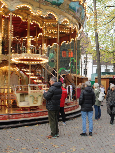 The people looking at the merry-go-round at the holiday market