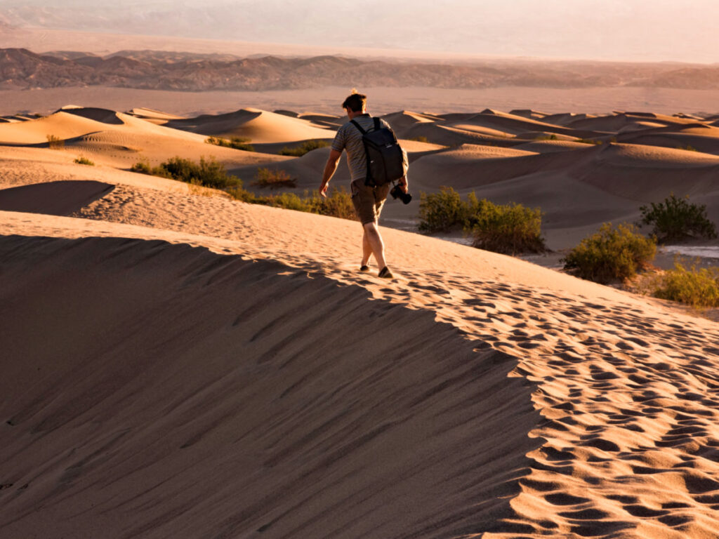 A man walking on the Mesquite Sand Dunes at dusk