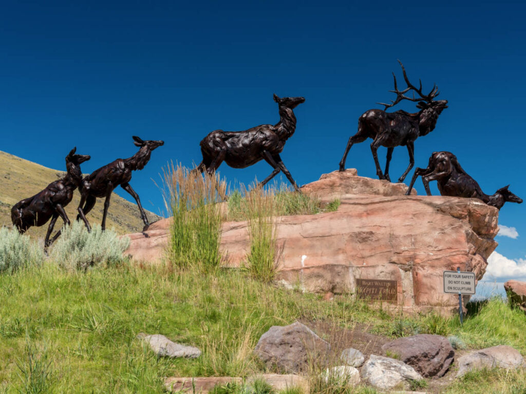 Perspective view of the metal deer sculptures on the rock