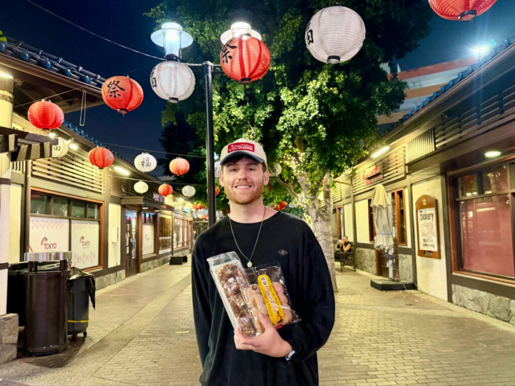 The author's boyfriend, Michael, carrying snacks in the street at night