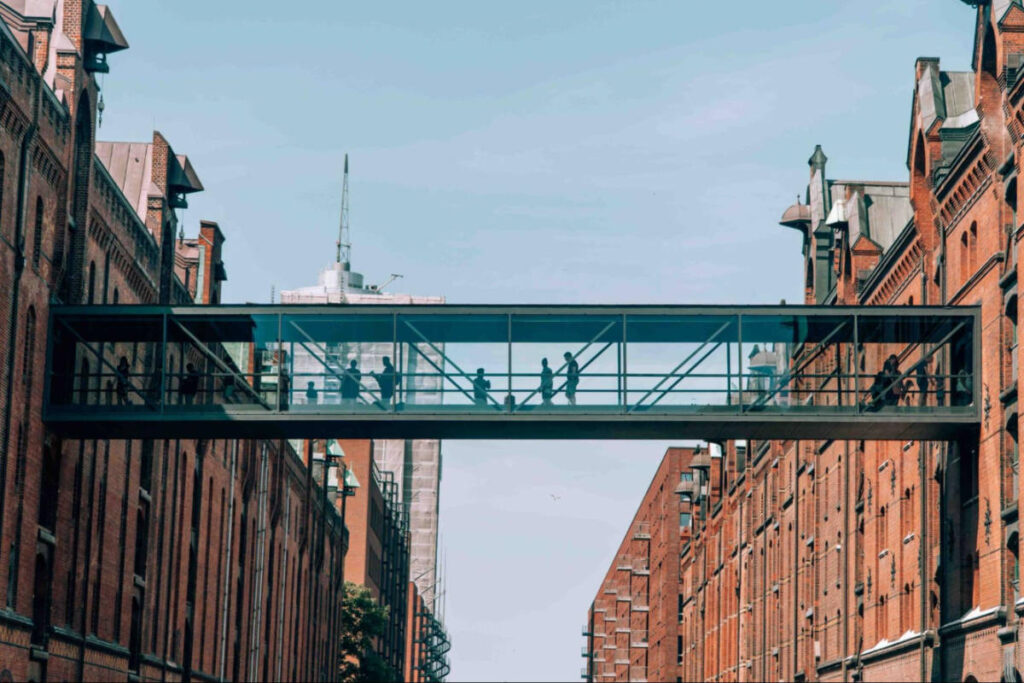 People crossing on the glass tunnel bridge seen from the outside