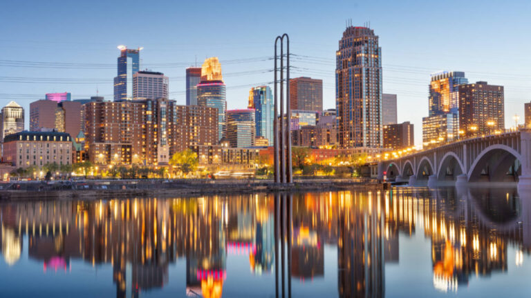 Panoramic view of the Minneapolis skyline and brdge reflecting on the water at dusk
