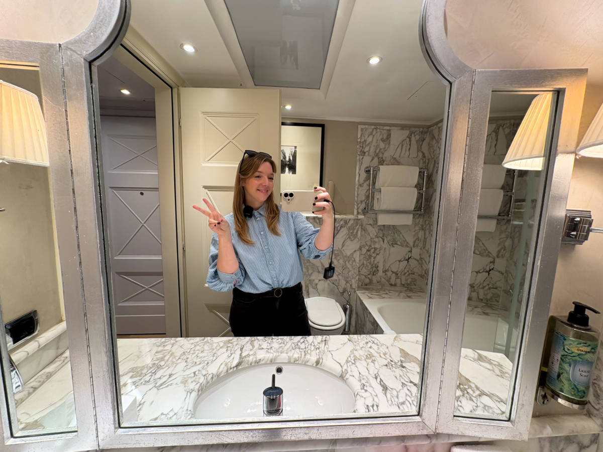 The author Taylor Herperger, smiling for a photo in front of the  mirror in in Splendid Venice