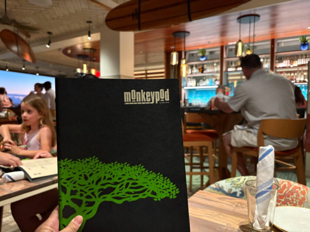 A hand holding the menu of Monkeypod