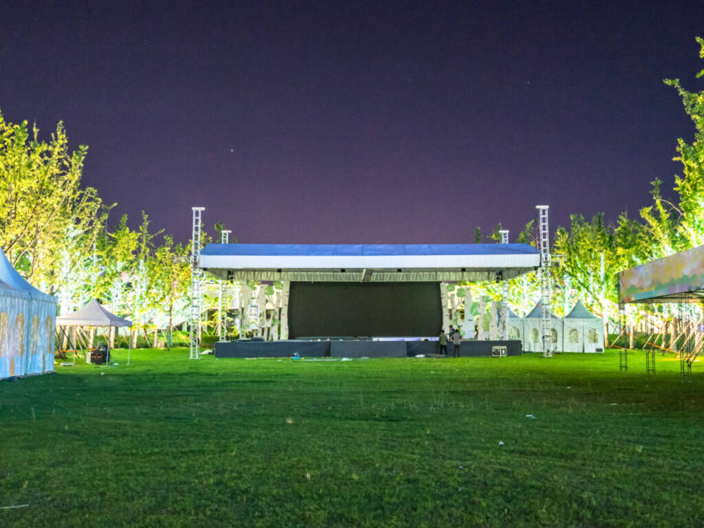 A stage in the middle of a grassy lawn at night