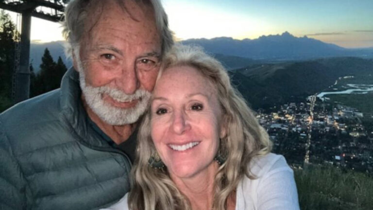 The author Morri Stewart and her partner smiling for a photo at the top of Snow King Resort