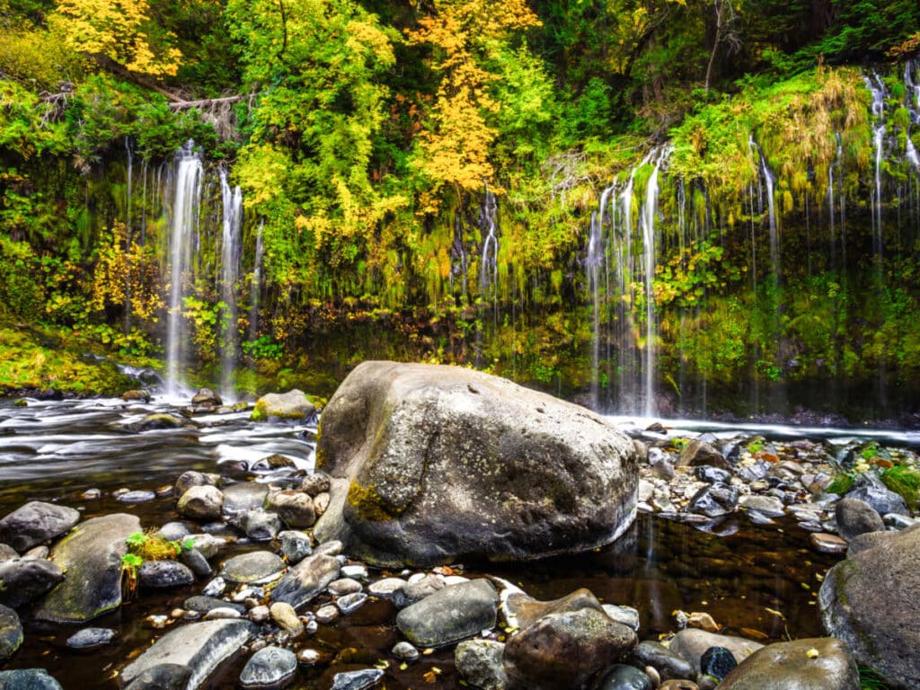View of the Mossbrae Falls surrounded by greenery and rocks