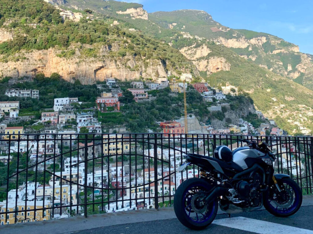 A motorcycle parked on a street in Italy, offering a view of a town