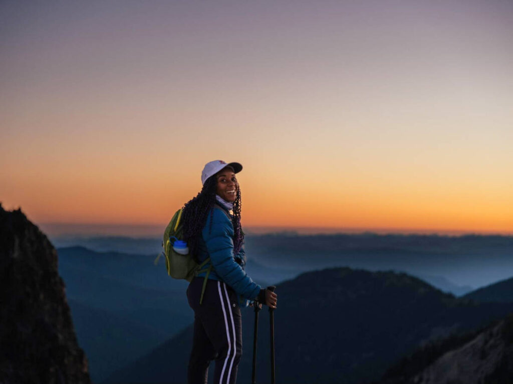 The author Chelsea Booker smiling for a photo in Mount Rainier National Park during sunrise