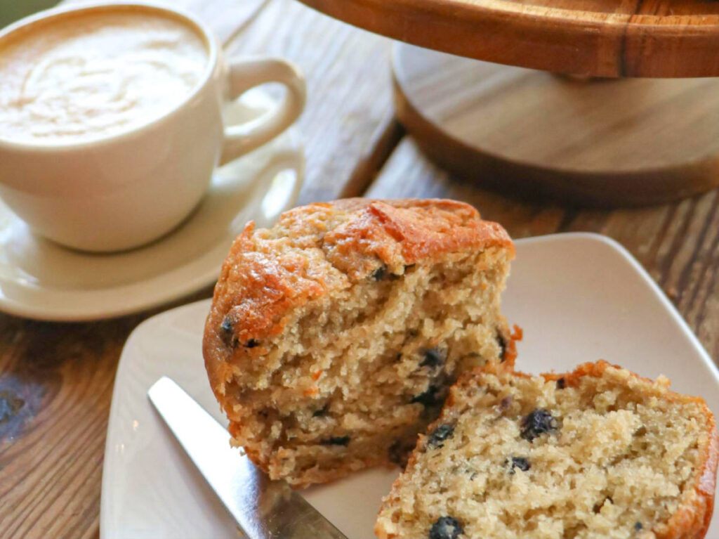 Closeup look of the muffin on the plate with a cup of coffee