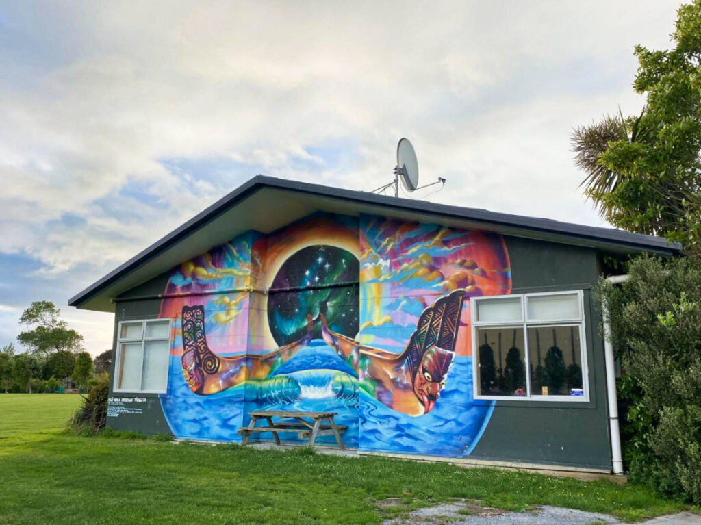 A colorful mural outside a small school building