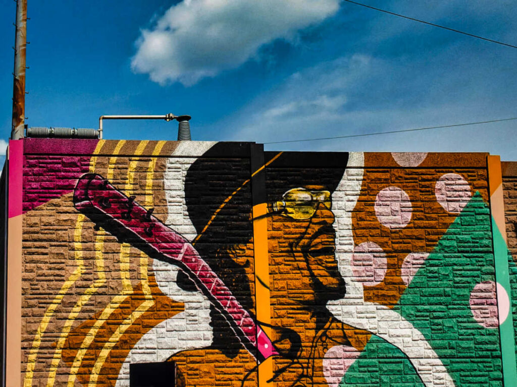 A huge colorful mural of Chuck Brown on the wall